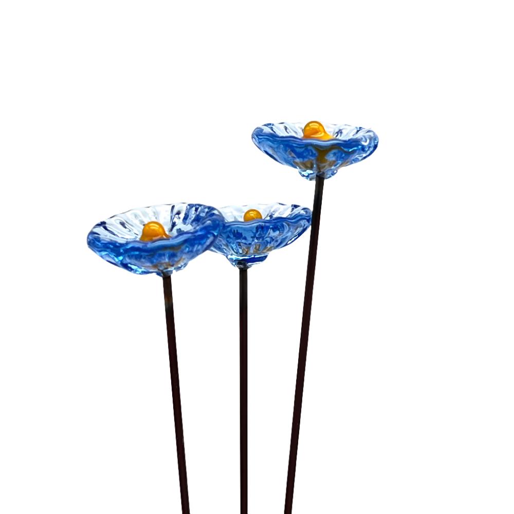 three transparent periwinkle blue glass daisies with yellow centres on metal stakes