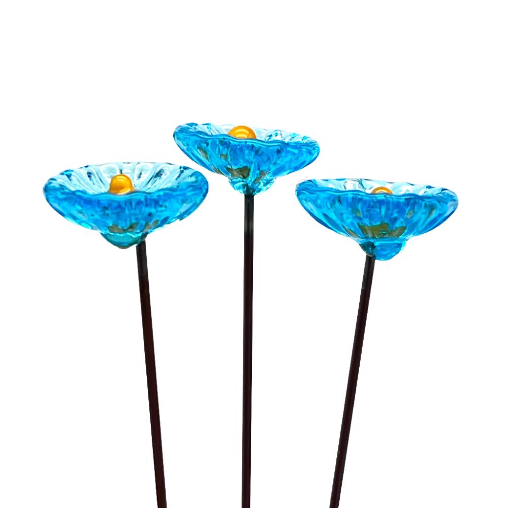 three transparent turquoise glass daisies with yellow centres on metal stakes