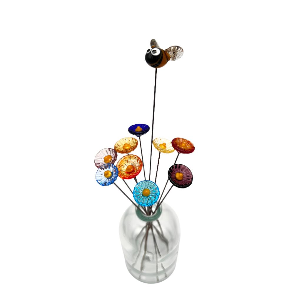 top down view glass bee and nine daisy flowers in a vase